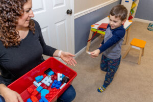 Boy exchanging a picture for a block.