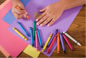 child colouring with crayons