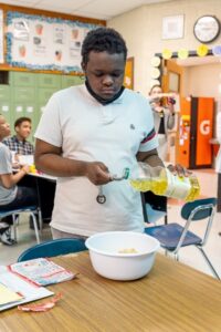 student participating in a baking lesson