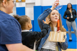 Teacher demonstrating a toy for a child to request.